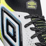 Championes de fútbol Umbro modelo Adamant, color blanco con detalles en negro, azul y amarillo neón. Presentan un diseño de media caña con cordones y tapones amarillos neón en la suela.
