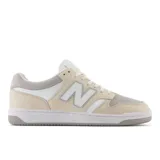 Championes urbanos New Balance modelo BB480, de caña baja, color crema con detalles en gris y blanco, con logo "N" característico en los laterales y suela de goma.