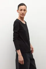 Remera de manga larga color blanco con escote a la base y corte recto.