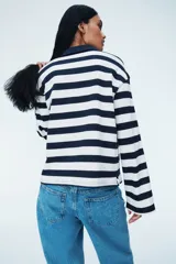 Remera polo de manga larga con cuello clásico y tapeta de botones. Diseño a rayas horizontales blancas y azul marino.