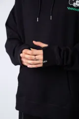 Buzo canguro negro de algodón friza, corte oversize y estampa de Mickey Mouse con detalles en verde.