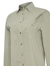 Camisa de manga larga color gris claro, con cuello camisero, cierre frontal con botones y dos bolsillos con solapa en el pecho. Confeccionada en algodón orgánico con tecnología UPF +50.