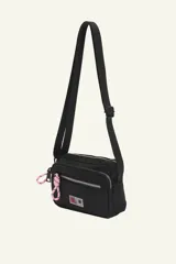 Bandolera negra con correa regulable para usar cruzada o al hombro. Cuenta con múltiples compartimentos con cierre y detalle de cordón rosa en el cierre.