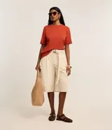 Remera de malla color blanco, de corte recto y mangas cortas con dobladillo.