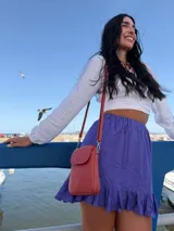 Bandolera pequeña de símil cuero color terracota, con solapa frontal y correa fina ajustable.