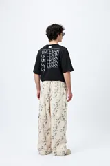 Pantalón cargo baggy con estampado abstracto en tonos neutros, bolsillos laterales y corte amplio.