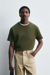 Camiseta verde militar de corte holgado confeccionada en tejido de algodón compacto. Cuello redondo con ribete doble y mangas cortas.