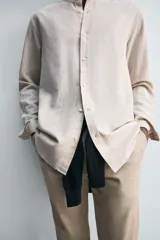 Camisa negra de lino y algodón, corte relaxed fit, cuello mao, manga larga con puños abotonados y cierre frontal con botones.