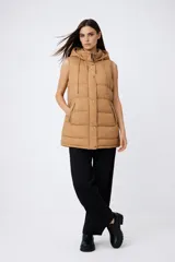 Chaleco puffer color tostado con capucha ajustable, cierre frontal con botones a presión y bolsillos laterales con cierre.