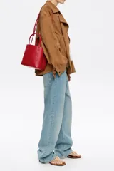 Bolso de mano negro Bimba y Lola modelo Chihuahua S, fabricado en piel regenerada con piezas de metal. Cuenta con asa regulable de piel, cierre con cinta de piel, logo metálico BIMBA Y LOLA, acabados metálicos, bolsillo interior con cierre de cremallera e interior con logo grabado.