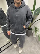 Conjunto deportivo gris con efecto lavado, compuesto por un hoodie con capucha, bolsillo canguro y logo "Bohemian Design" estampado en el pecho, y un pantalón jogging de corte holgado.