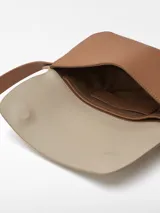 Riñonera color tostado y beige con correa ajustable y cierre magnético.
