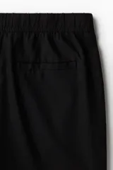 Pantalón negro de lino y viscosa, corte recto, con cintura elástica ajustable con cordón.