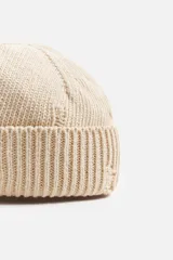 Gorro de lana tejido en punto morado oscuro, con vuelta y detalles rotos.