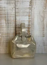 Mini bag tipo limosnera color negro charolado, con asa corta superior.