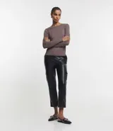 Suéter de punto color verde, con cuello barco, mangas largas y textura acanalada.