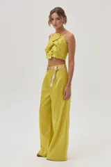 Pantalón sastrero de tiro alto color verde lima, confeccionado en tafeta metalizada, con calce holgado y pierna ancha.