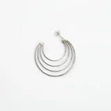 Aros plateados de acero quirúrgico con diseño de múltiples aros concéntricos.