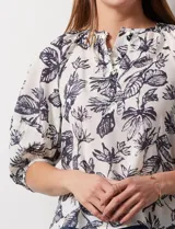 Blusa de gasa blanca, marca Sioni. Cuello a la base y escote en V con botones.