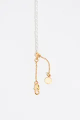 Collar corto de perlas con dijes de corazón multicolor con detalles dorados.