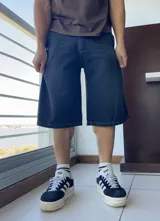 Bermuda de jean azul oscuro, corte ancho a la rodilla.