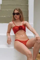 Bikini color ocre con corpiño strapless con detalle de flor en el centro y bombacha clásica.