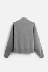 Jersey azul marino de punto suave, corte regular, cuello alto con cremallera frontal, manga larga y terminaciones en rib.