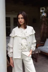 Campera de jean gris oscuro con volados en el frente y las mangas, de corte recto y largo a la cadera.