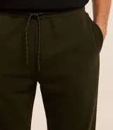 Pantalón jogger color beige confeccionado en algodón y poliéster, con cintura elástica ajustable con cordón, bolsillos laterales y tobillos elastizados.