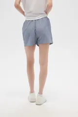 Short de viscosa a rayas verticales azules y blancas, con cintura elastizada y cordón ajustable.