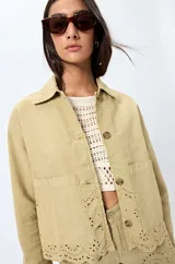 Sobrecamisa blanca de algodón con cuello camisero, botones marrones y detalles de encaje calado en el ruedo.