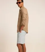 Bermuda masculina de corte slim, confeccionada en sarga lisa color blanco. Cuenta con bolsillos laterales, cierre con botón y cremallera, y trabillas para cinturón.