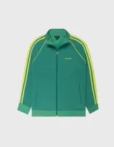 Campera deportiva de tejido doble faz, color verde esmeralda, con cuello alto y cierre frontal. Presenta tres franjas deportivas amarillas a lo largo de las mangas raglán. Logo de la marca bordado en el pecho.