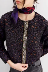 Campera bomber con estampado animal print, cuello redondo y corte a la cintura. Presenta detalle de cartera bordada en piedras y strass.