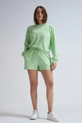 Short deportivo verde claro de tela French Terry, con cintura elástica ajustable con cordón.