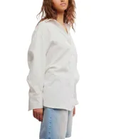 Camisa blanca de algodón con cuello clásico, manga larga y cierre frontal con botones. Tiene un bolsillo en el pecho y corte ligeramente entallado.