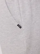 Bermuda deportiva gris confeccionada en 60% algodón y 40% poliéster, con cintura elástica ajustable con cordón.