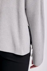 Sweater gris de punto inglés con cuello redondo y mangas largas.