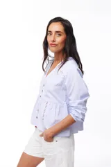 Blusa celeste a rayas verticales con escote en V, mangas largas y botones frontales.