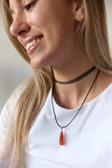 Gargantilla doble con choker de cuero negro y collar con dije de piedra natural marrón en forma de gota con engarce de acero quirúrgico hipoalergénico y tiento negro.