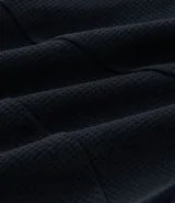 Pantalón deportivo negro de tela texturizada, con cintura elástica y bolsillos con cierre.