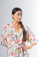 Bata kimono corta de algodón estampado con flores rojas, violetas y verdes. Tiene mangas al codo y lazo de ajuste en la cintura.