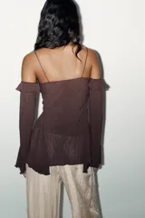 Top marrón con textura arrugada, escote pico con volantes y lazada cruzada, hombros descubiertos, manga larga acampanada y tirantes finos.