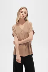 Blusa color beige de lino, holgada y con cuello en V.