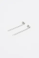 Caravanas largas de color negro con diseño de corazones en cascada. Presentan una serie de cristales facetados en forma de corazón engarzados en una estructura de acero inoxidable con acabado metálico oscuro y cierre a presión.