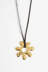 Collar con cordón de suede negro y dije de flor irregular de acero dorado.