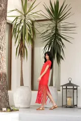 Vestido de algodón color rojo con cuello redondo y corte recto. Presenta mangas cortas y flecos en el ruedo.