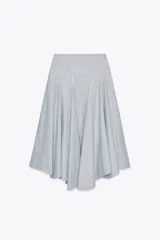 Falda midi de tiro medio con estampado de rayas verticales azules y blancas. Presenta costura de cintura asimétrica, detalle de pliegues y cierre lateral con cremallera oculta.
