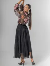 Falda estilo ballet core confeccionada en gasa negra con pequeños destellos que aportan brillo sutil y movimiento. Tiene cintura elastizada.