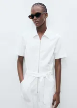 Mono largo blanco de algodón con cuello camisero, manga corta, cierre frontal con cremallera, cinturón desmontable y bolsillos laterales.